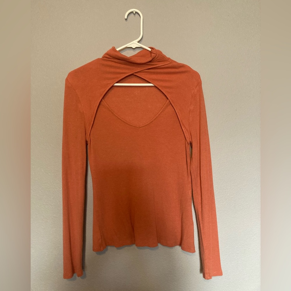 Orange women’s long sleeve ribbed top with cutouts.